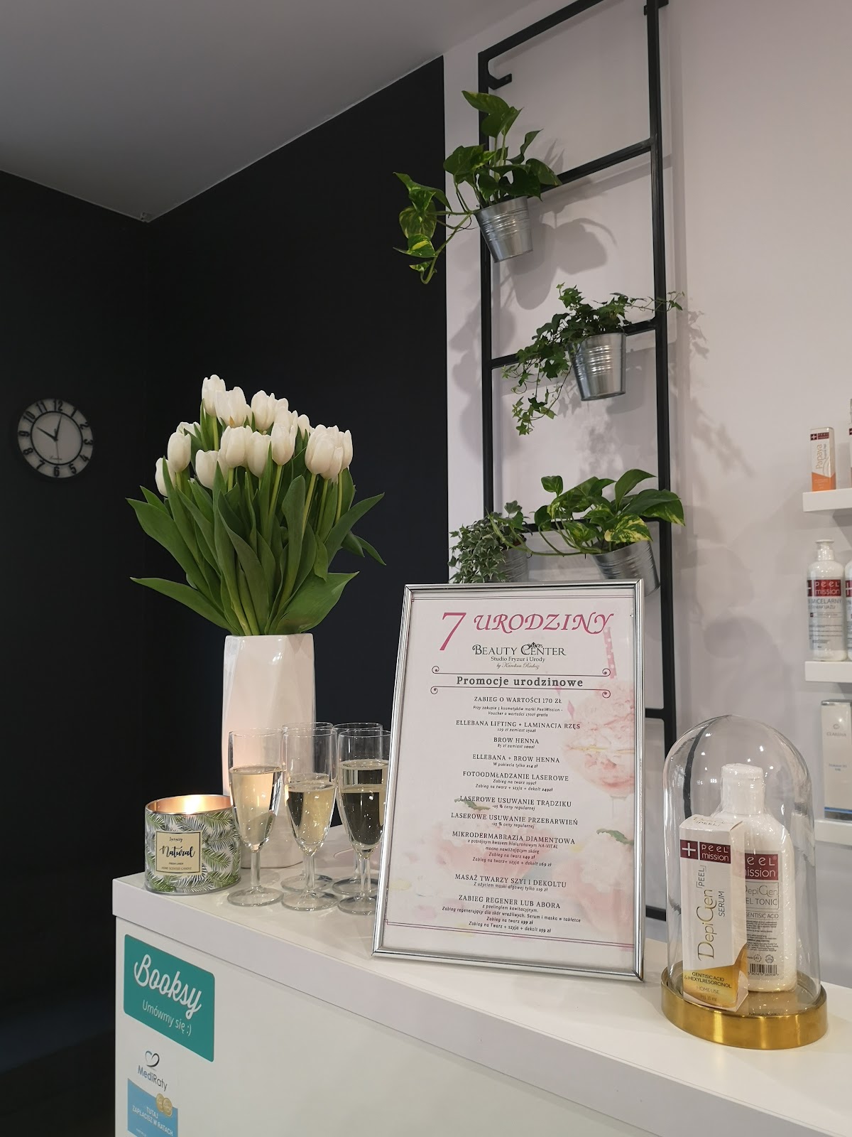 Recepcja salonu z bukietem białych tulipanów i ramką z promocjami urodzinowymi